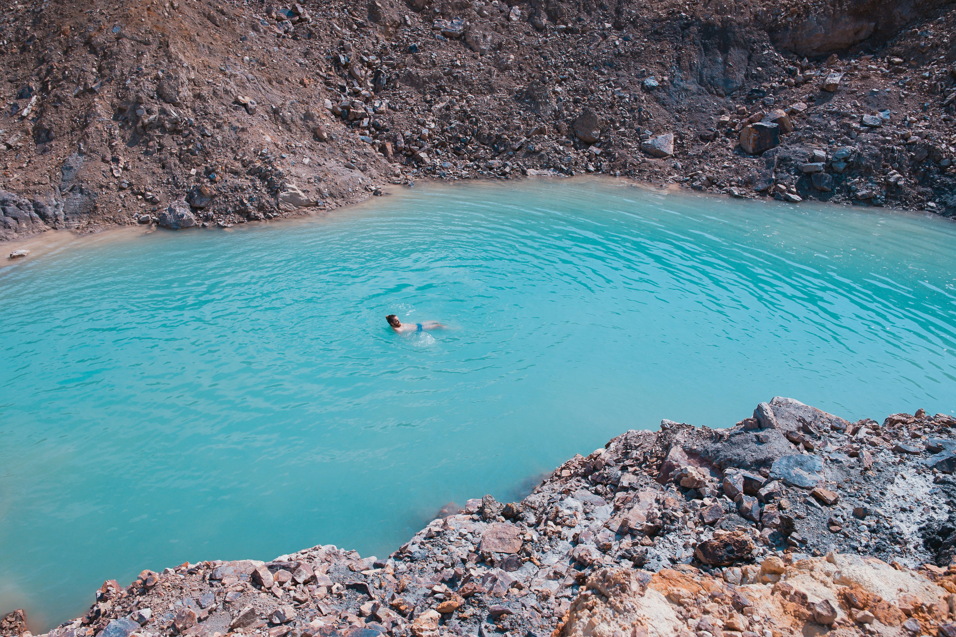 man swims on body of water